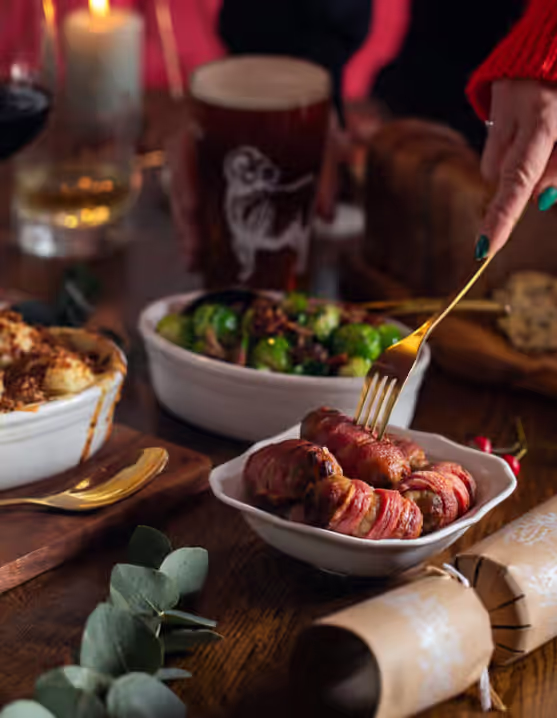 Christmas dinner table with sausages, wine, and Young's beer