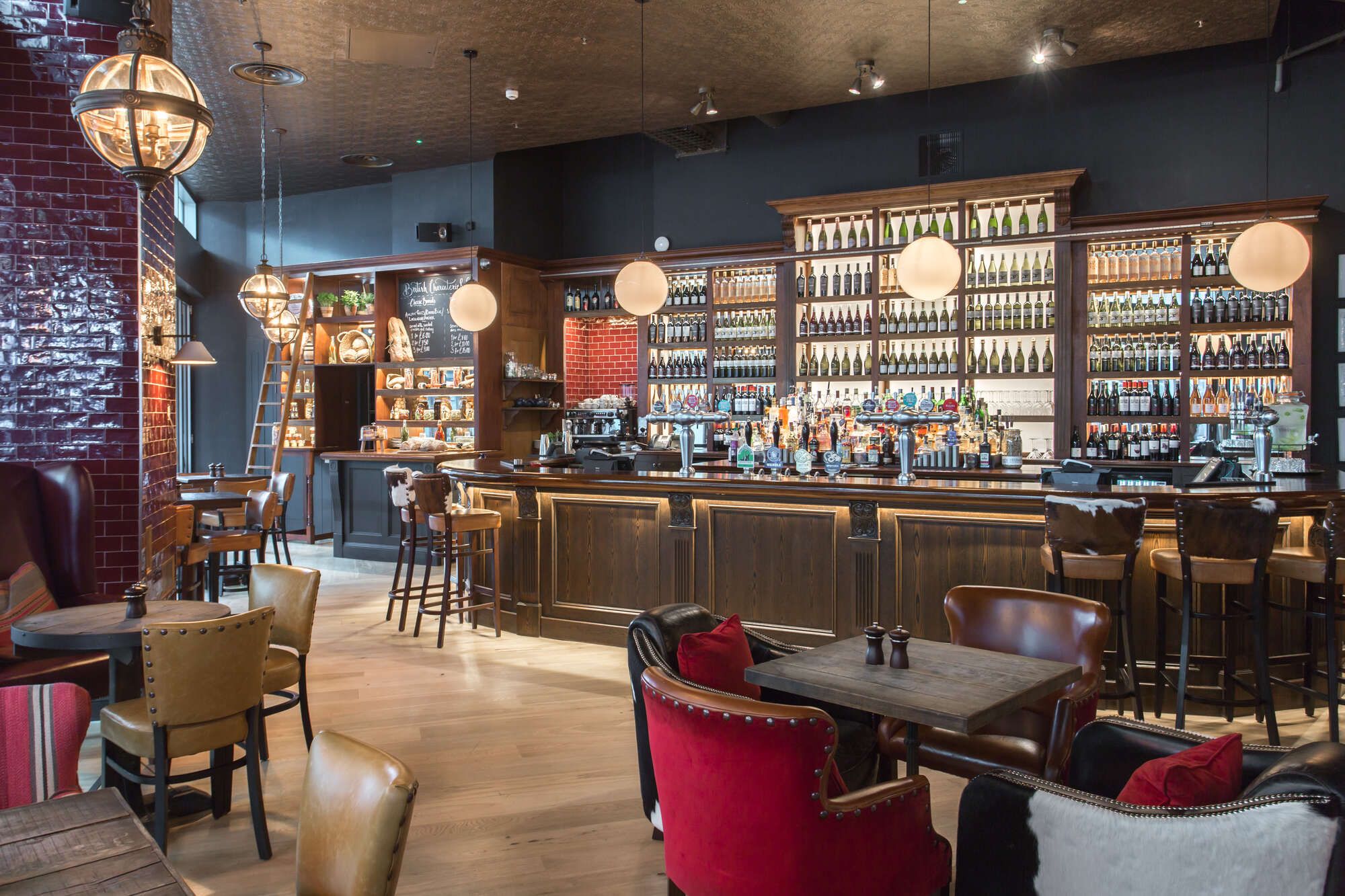 Downstairs bar with back bar lit up and filled with various spirits and wines