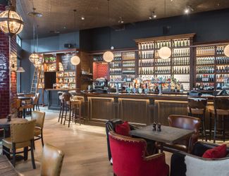 Downstairs bar with back bar lit up and filled with various spirits and wines
