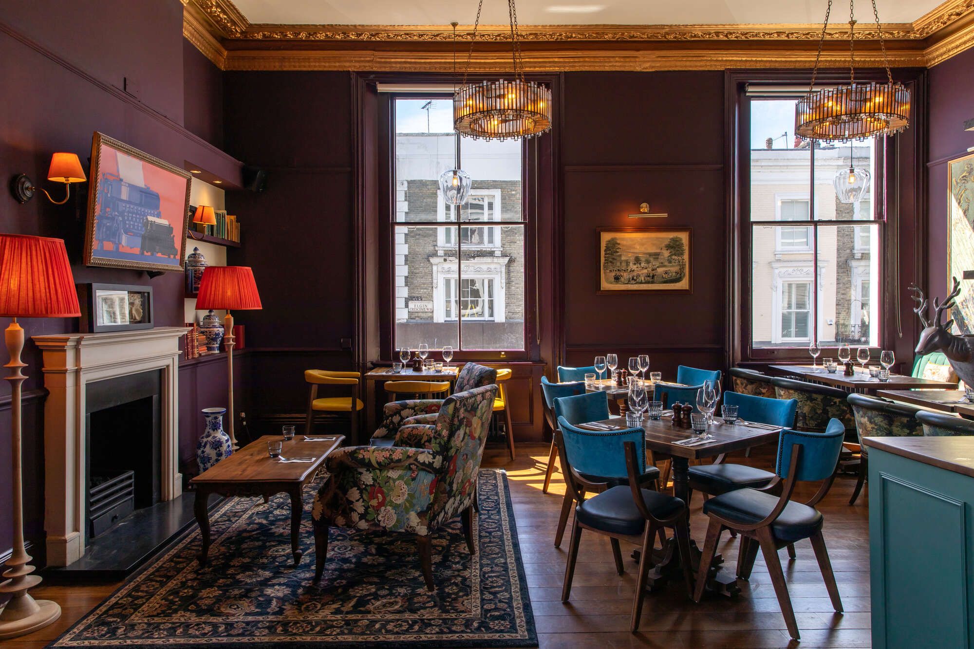 upstairs private dining area with tables and chairs across the room and a TV on the wall