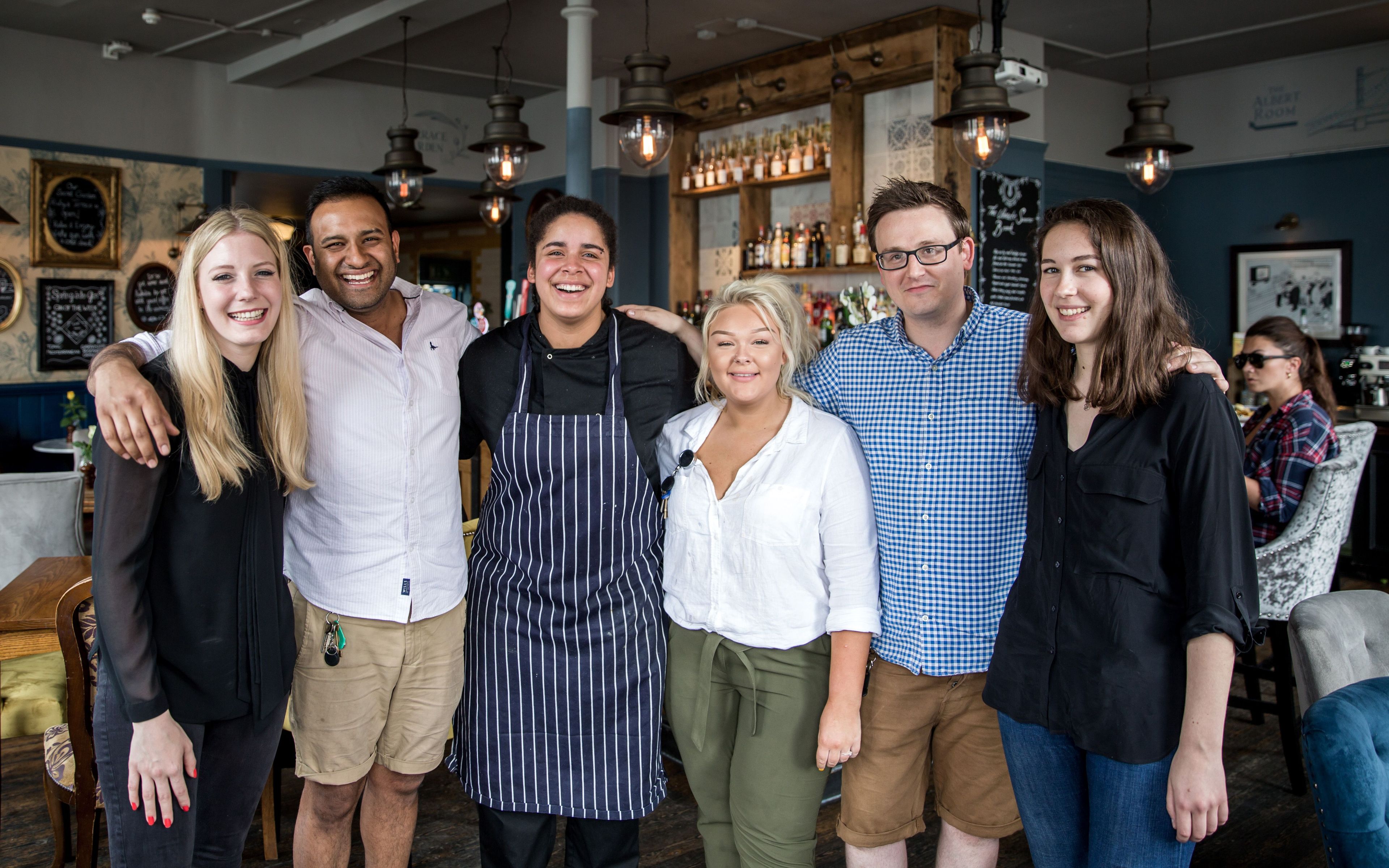 group of Young's staff with their arms around each other inside a Young's pub