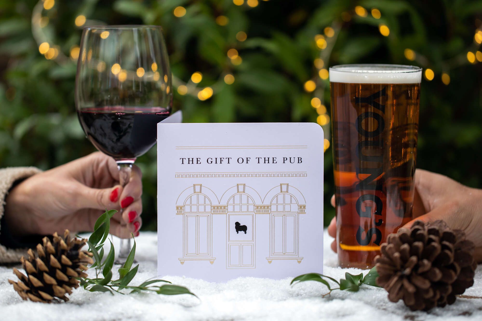 Young's gift voucher on a table with pinecones, wine and a Young's pint