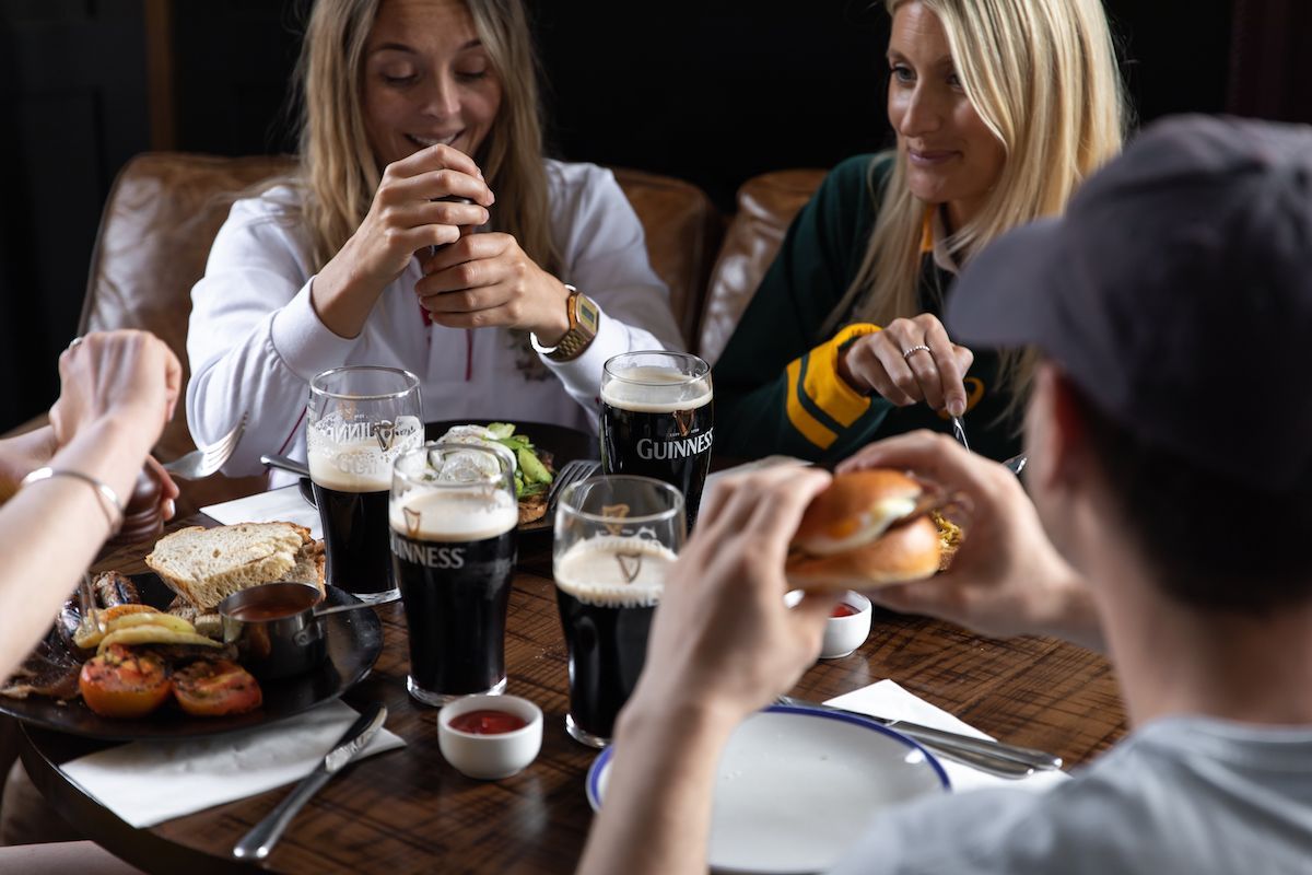 friends sharing Guinness and food at a Young's pub