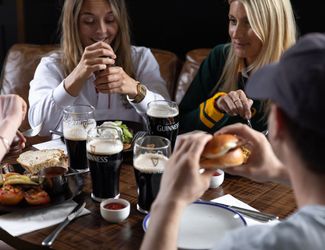 friends sharing Guinness and food at a Young's pub