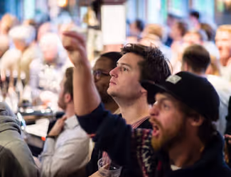 people cheering and watching a game at a Young's pub