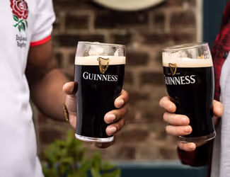 two people holding pints of Guinness